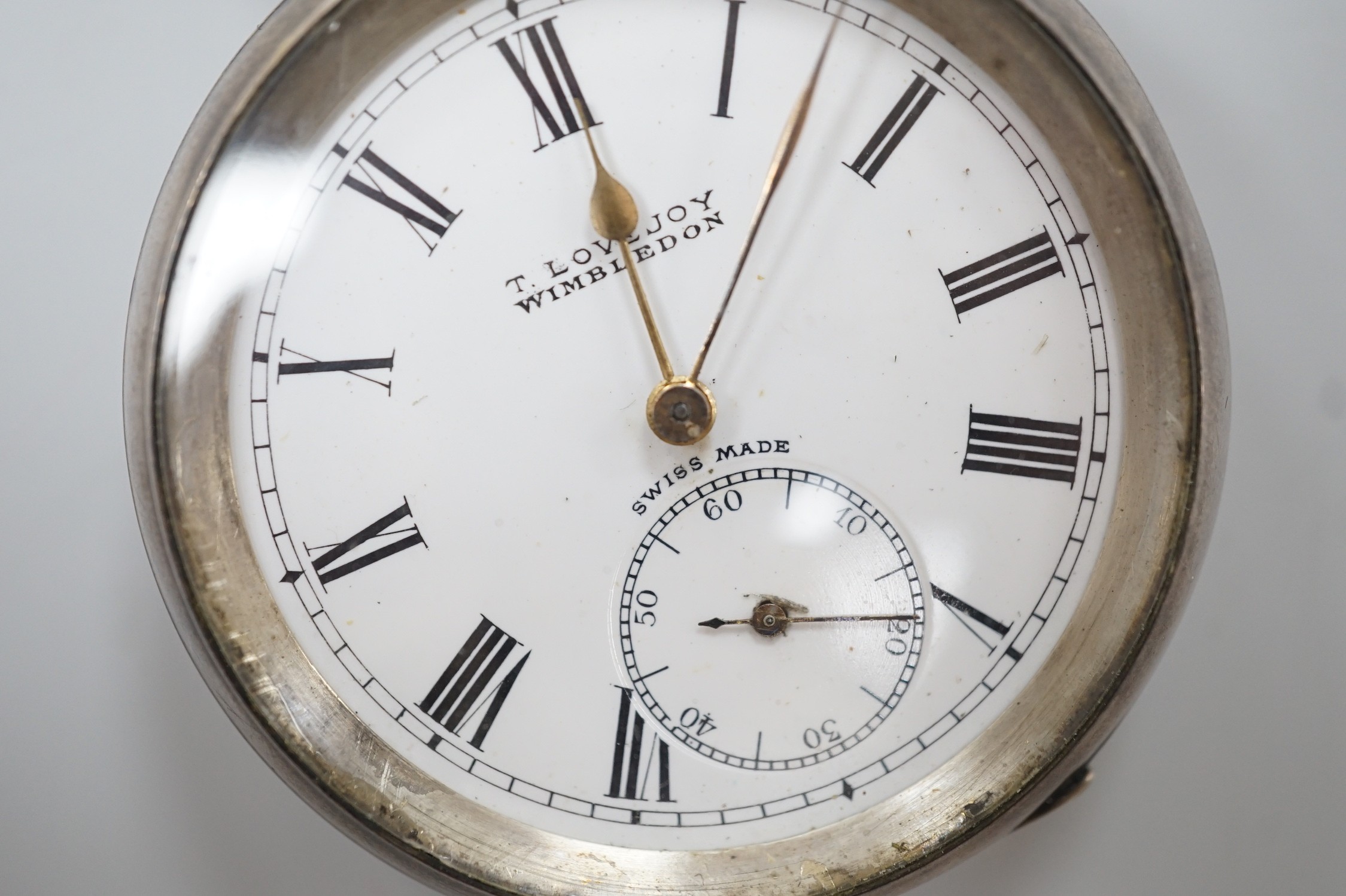 A Swiss open faced keywind pocket watch, retailed by Lovejoy, Wimbledon, with Roman dial and key.